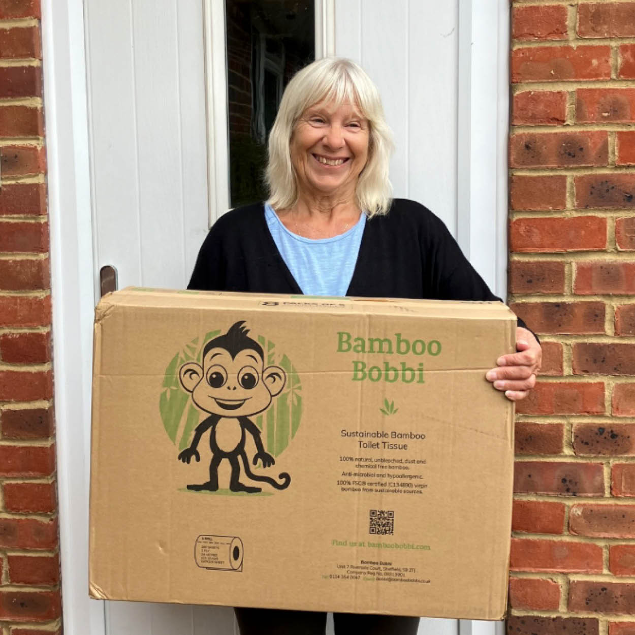 Woman holding a box of Bamboo Bobbi and smiling
